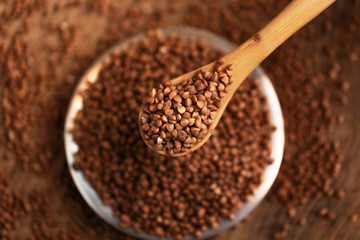Buckwheat in bowl on table, spoons, top view 