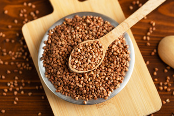 Buckwheat in bowl on table, spoons, top view 