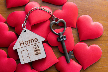 House key with home keyring decorated with mini heart on rusty wood background - 326698214