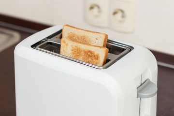 Slices of toasted bread in a white toaster.