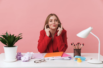 Woman sit at the table holding pencil.