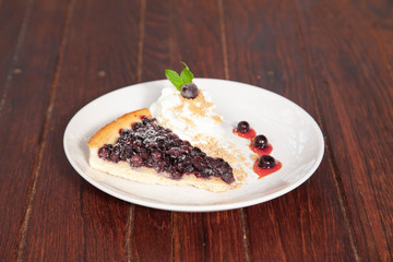 Sliced blueberry pie with fresh whipped cream and cookie crumble