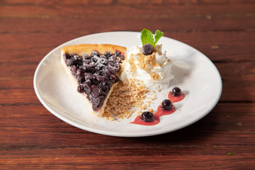 Sliced blueberry pie with fresh whipped cream and cookie crumble