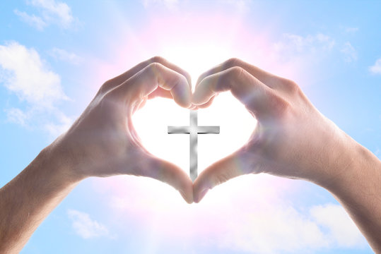Hands forming a heart in heaven with spikes surrounding cross