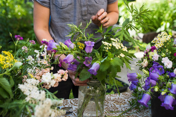 Gardener creating fresh cut bouquet of flowers