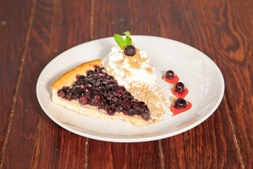 Sliced blueberry pie with fresh whipped cream and cookie crumble