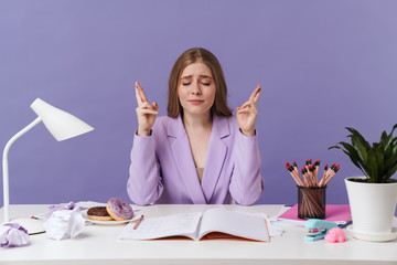 Woman sit at the table showing hopeful gesture.