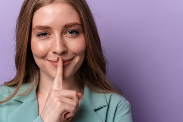 Smiling woman showing silence gesture