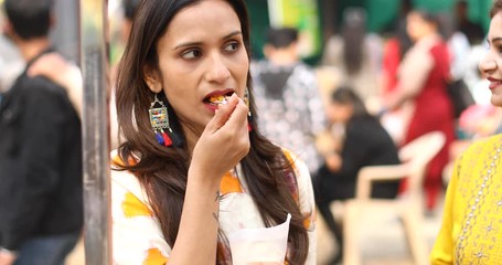 Woman eating healthy corn at street market