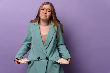 Sad displeased woman showing empty pockets.