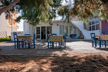 Tables and chairs of a typical restaurant on the coast of the island of Crete.