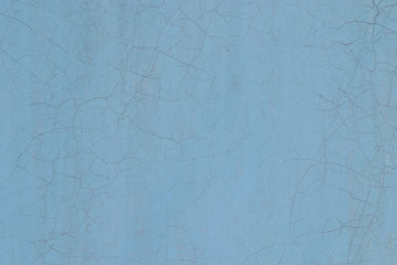 Blue wall painted with oil paint. Texture, background. The surface of the wall is worn and covered with cracks.