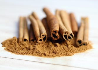 Cinnamon powder and sticks.   Aromatic spice of cinnamon on the white wooden table