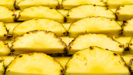Pineapple juicy yellow slices background. Top view.