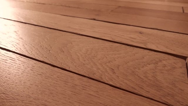 Camera flying very close to rustic oak parquet floor.