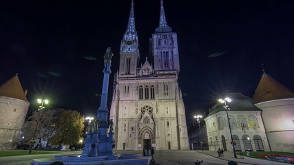 Fototapeta premium Entrance to Zagreb Cathedral night timelapse and Monument called Maria's pillar. ZAGREB, CROATIA