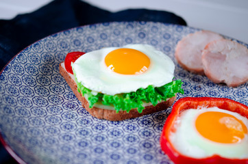 Traditional breakfast. The fried eggs with ham, salad and toast lies on a large plate