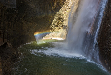 Fototapeta na wymiar Rainbow at the HaTanur waterfall flows from a crevice in the mountain and is located in the continuation of the rapid, shallow, cold mountain Ayun river in the Galilee in northern Israel