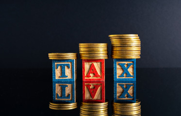 Coins stacking and tax letter cube with low light view.