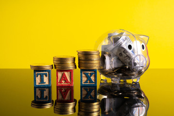 TAX letter and stacking coins with financial concept. Image in low light view.