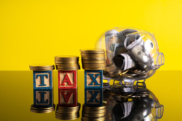 TAX letter and stacking coins with financial concept. Image in low light view.