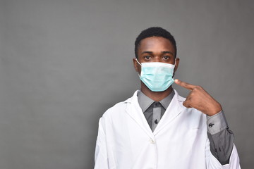 young black man in medical field, wearing a white coat indicating wearing a face mask