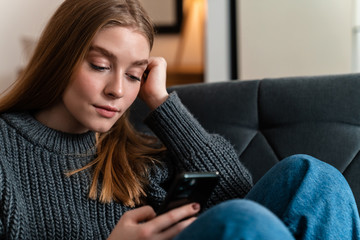 Obraz premium Woman indoors at home using mobile phone.