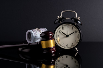 Naklejka premium Gavel hammer, banknotes and clock with ow light view. Financial concept.