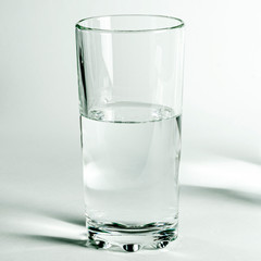 Pure clear water in a glass and jug stands on a white background