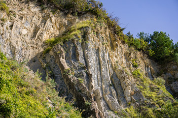 Natural texture of Caucasus Mountains on the rocky coast of Black Sea in Olginka. Pines and shrubs grow on steep stone slopes. Stones and rock fragments of different sizes as original background.