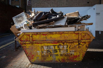 skip full of rubbish on side street - obrazy, fototapety, plakaty