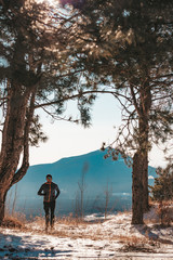 A man runs in the woods in winter sports