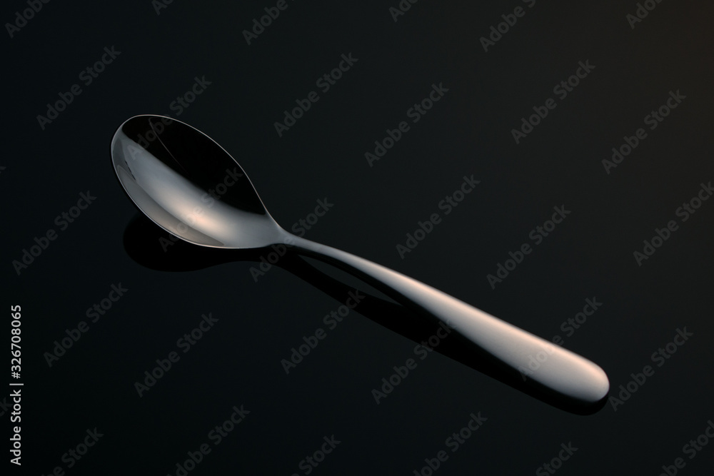 Wall mural teaspoon on a black mirror surface