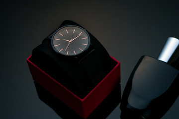 Wristwatch in a red box on a dark background.Watch in a case on a black velvet pillow