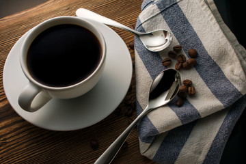Spoons on a towel with coffee beans on a wooden table.coffee beans on a towel.