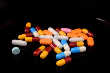 capsules falling on isolated black background.Medicine, medical, pharmaceuticals. The use of drugs in large quantities idea concept.