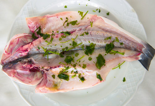 Plato con una lubina cruda y perejil