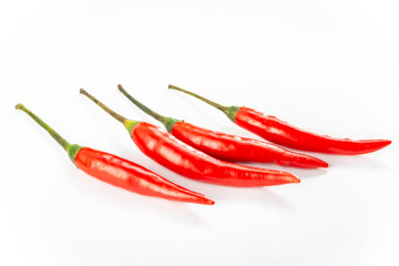 Four fresh red peppers are isolated on white background.