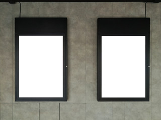 Black frame advertising signs with white background on bare cement or concrete wall