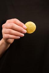 Young woman holding potatoe chips.