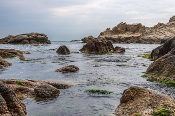 Fototapeta na wymiar Nice landscape of rocks with calm sea and blue background in Costa Brava, Lloret de Mar