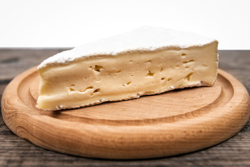 delicious brie cheese on wooden plate