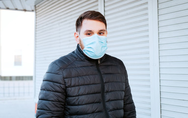European coronavirus. Portrait of caucasian man wearing facial hygienic mask, respiratory...