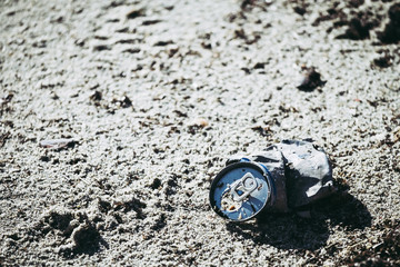 Cannette en métal sur le sable, déchet et pollution de la mer