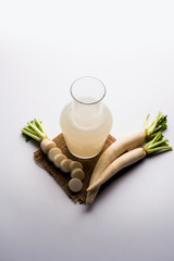 Healthy Fresh daikon juice or Mooli extract drink in a glass with raw mule