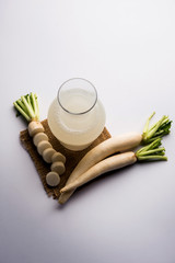 Healthy Fresh daikon juice or Mooli extract drink in a glass with raw mule
