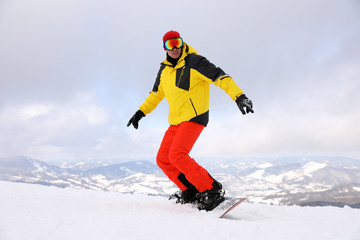 Male snowboarder on snowy hill. Winter vacation
