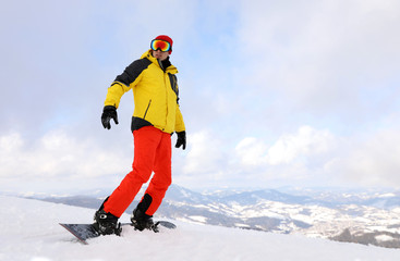 Male snowboarder on snowy hill. Winter vacation