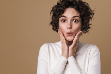 Image of excited beautiful woman expressing surprise at camera