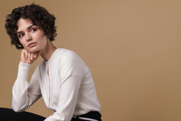 Image of nice beautiful woman looking aside while sitting